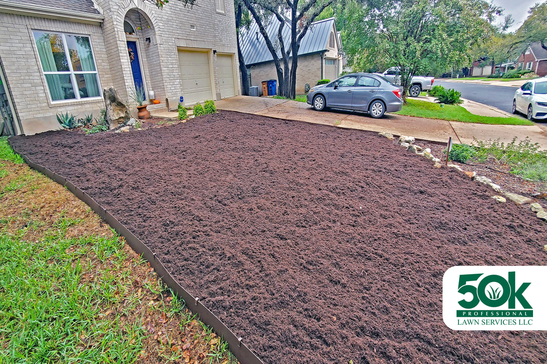 Enhanced curb appeal in South Austin, with newly laid black mulch.