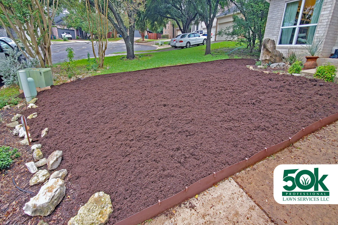 Aesthetic improvement of a yard in South Austin with top-grade brown mulch.